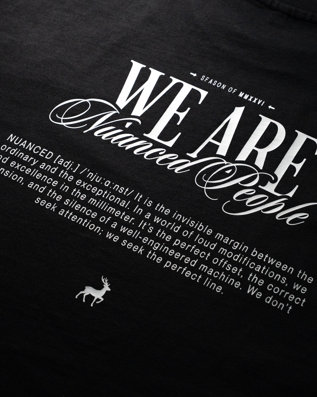 Nuanced People – Season of 2026 Backprint Rückendruck eines schwarzen T-Shirts mit weißem "WE ARE Nuanced People" Schriftzug, Definitionstext und Hirsch-Logo.